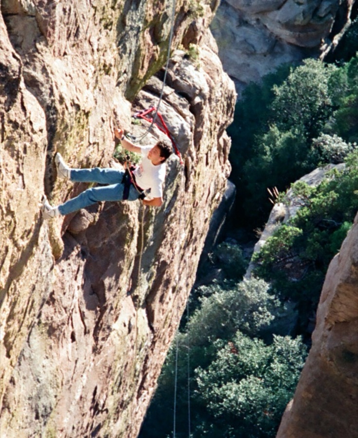 Steven climbing a steep rock face