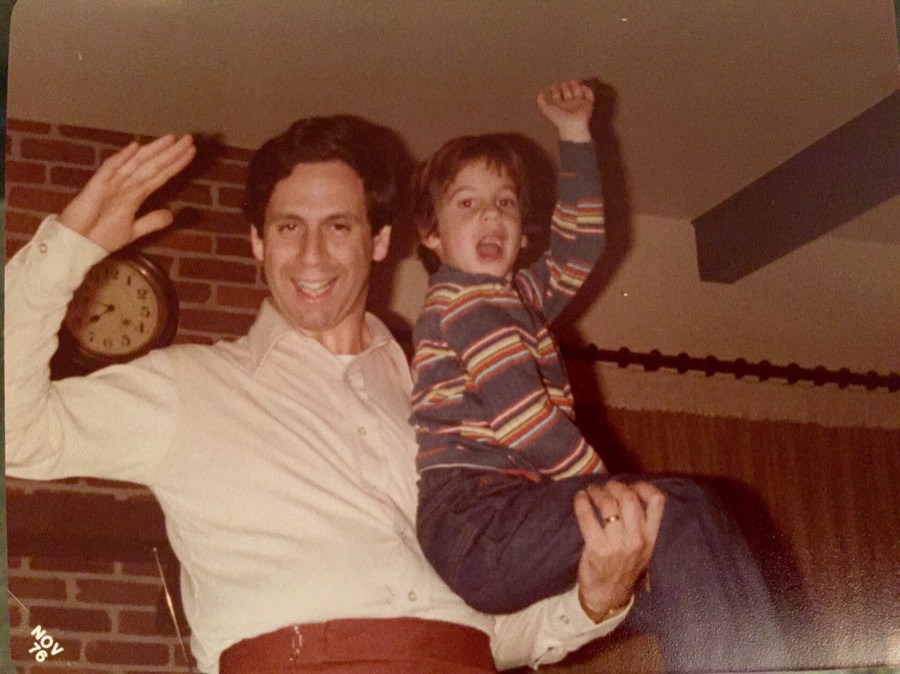Steven at six, lifted up by his father, both of them waving