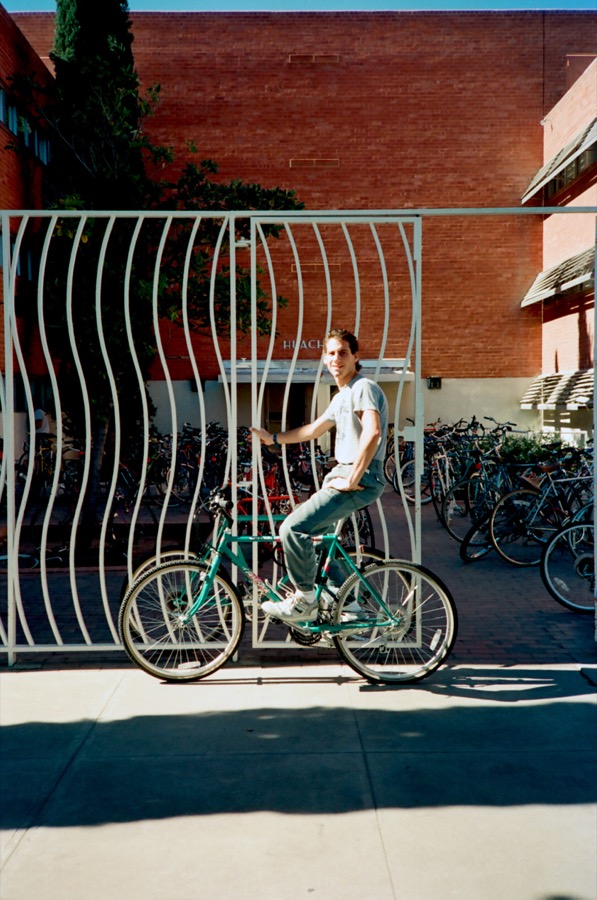 Steven on his mountain bike outside a campus building