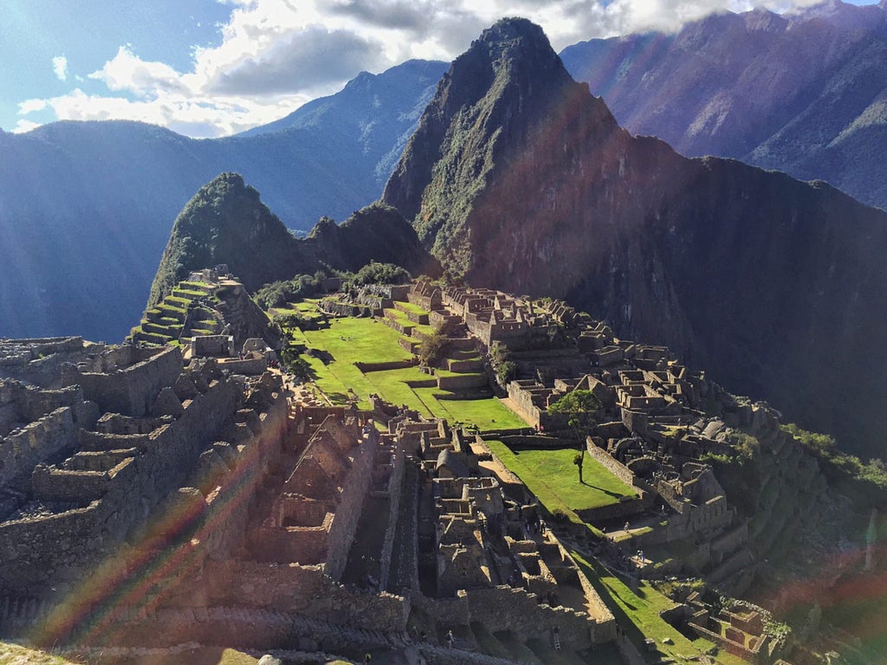 Machu Picchu in sunlight, with Huayna Picchu rising behind the ruins